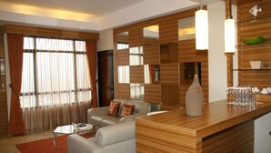Una sala de estar moderna con un sofá, una mesita de centro y un mostrador de recepción de madera.