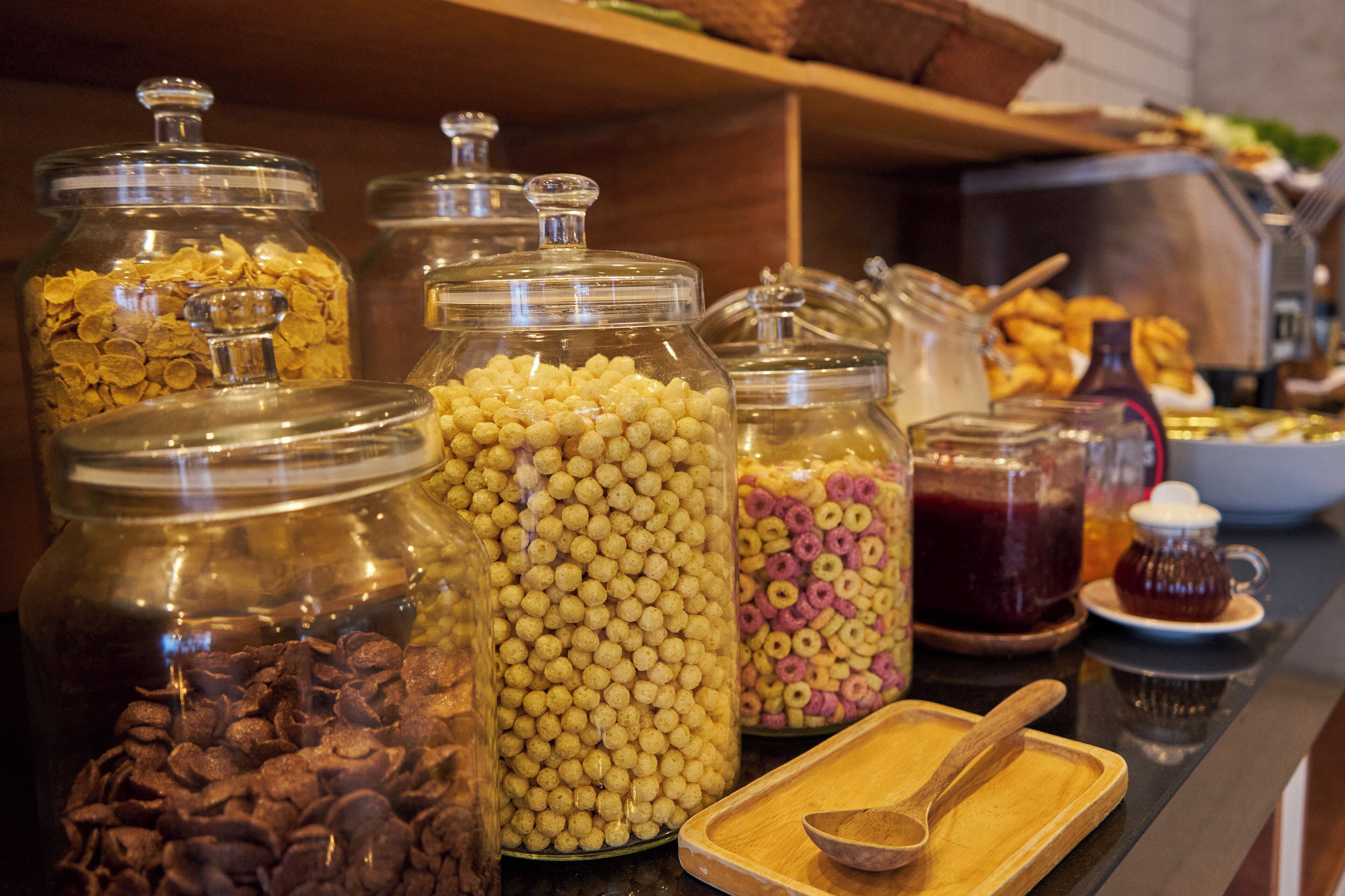A buffet with various food items in glass containers.