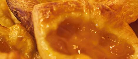 A close-up of a baked pastry with a golden-brown crust and a glossy, caramelized surface.
