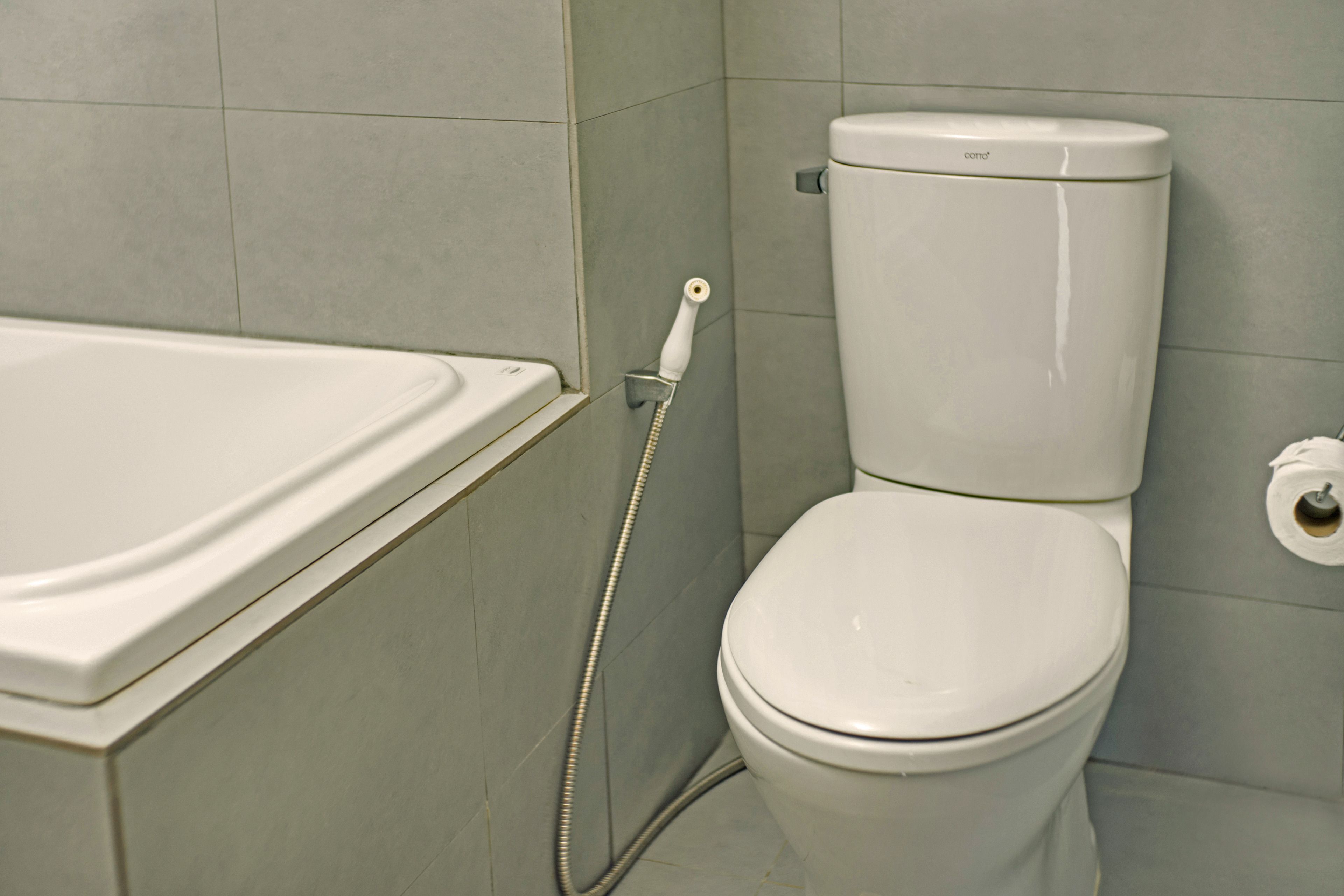 Et badeværelse med et hvidt badekar og toilet.