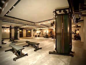 Un gimnasio con diversos equipos de ejercicio, como cintas de correr y máquinas de pesas.