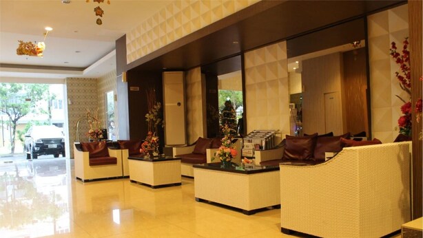 A spacious lobby with a reception desk, comfortable seating areas, and a Christmas tree. - Hotel Grand Imawan (Makassar)