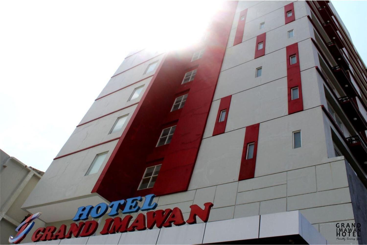 Un immeuble d’hôtel à plusieurs étages, caractérisé par une façade rouge et blanche bien visible.