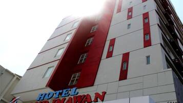 Un immeuble d’hôtel à plusieurs étages, caractérisé par une façade rouge et blanche bien visible.