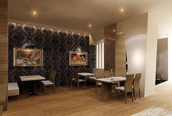 A dining area with a patterned wallpaper, two framed artworks, and a mix of wooden and upholstered chairs.