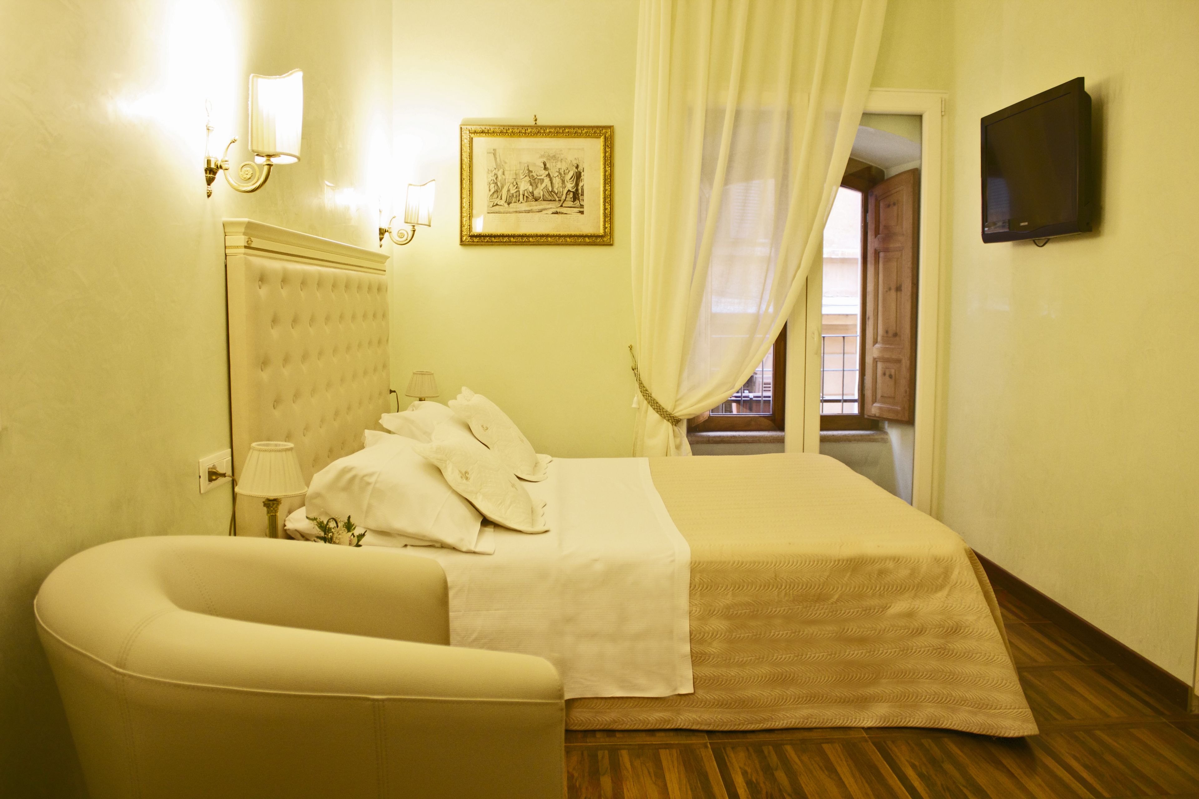 Una habitación de hotel con una cama grande, un área de descanso, un televisor y un cuadro en la pared.