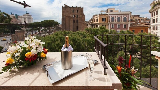 A balcony with a metal tray, a bottle of champagne, and a glass. - Hotel Romano (Rome)