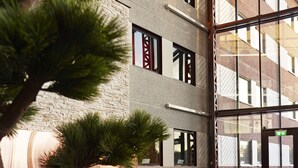 Un interior moderno con una pared de piedra, una chimenea y una zona de estar con sofá y sillones.
