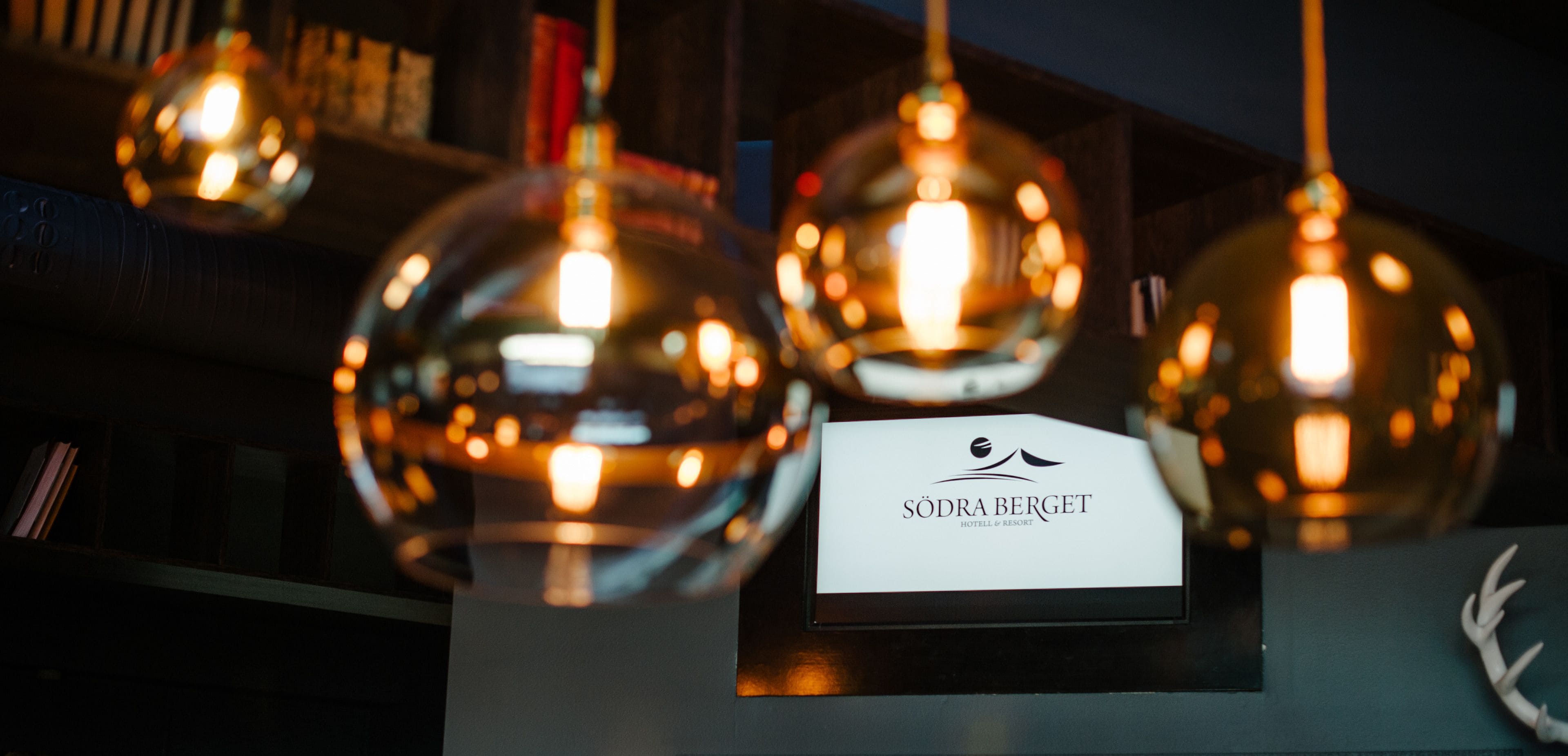 Señal de Sodra Berget Hotel & Resort con una moderna lámpara esférica colgante.