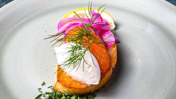 Un plato con comida, decorado con hierbas y una rodaja de limón.