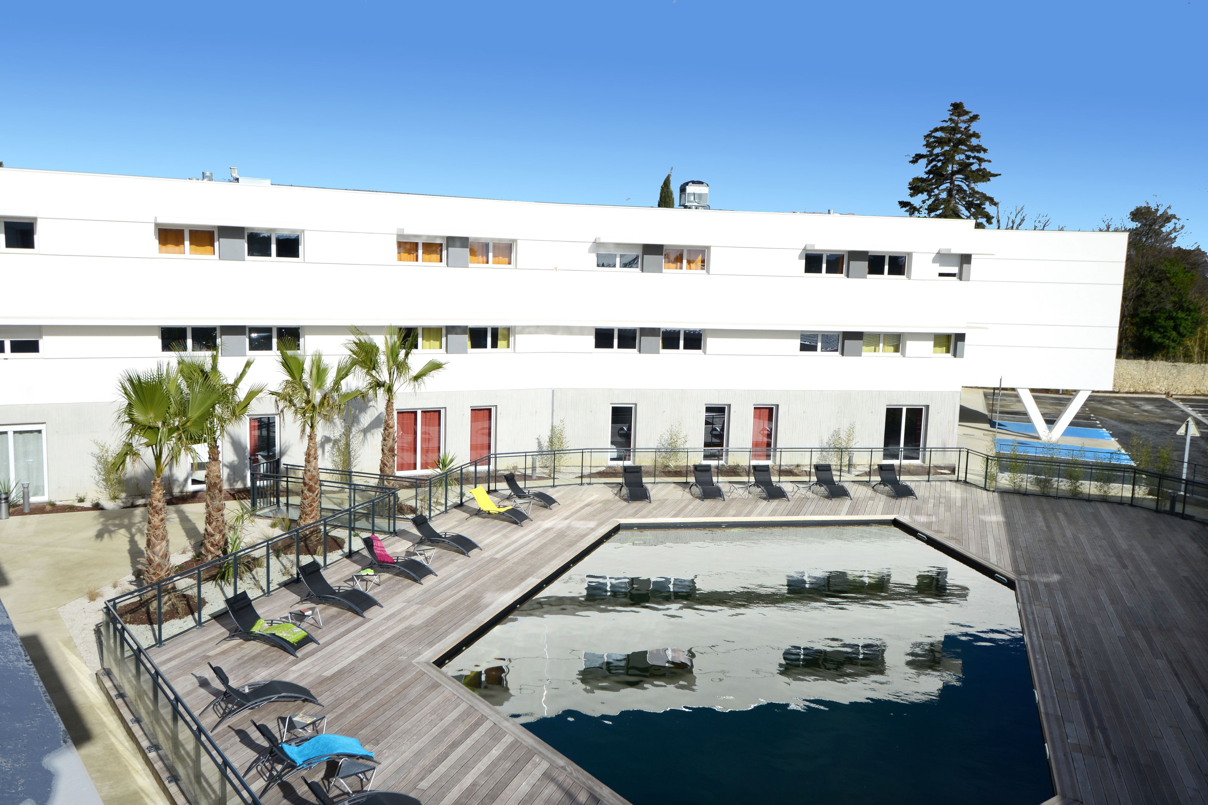 Una piscina al aire libre de temporada, sillones reclinables de piscina