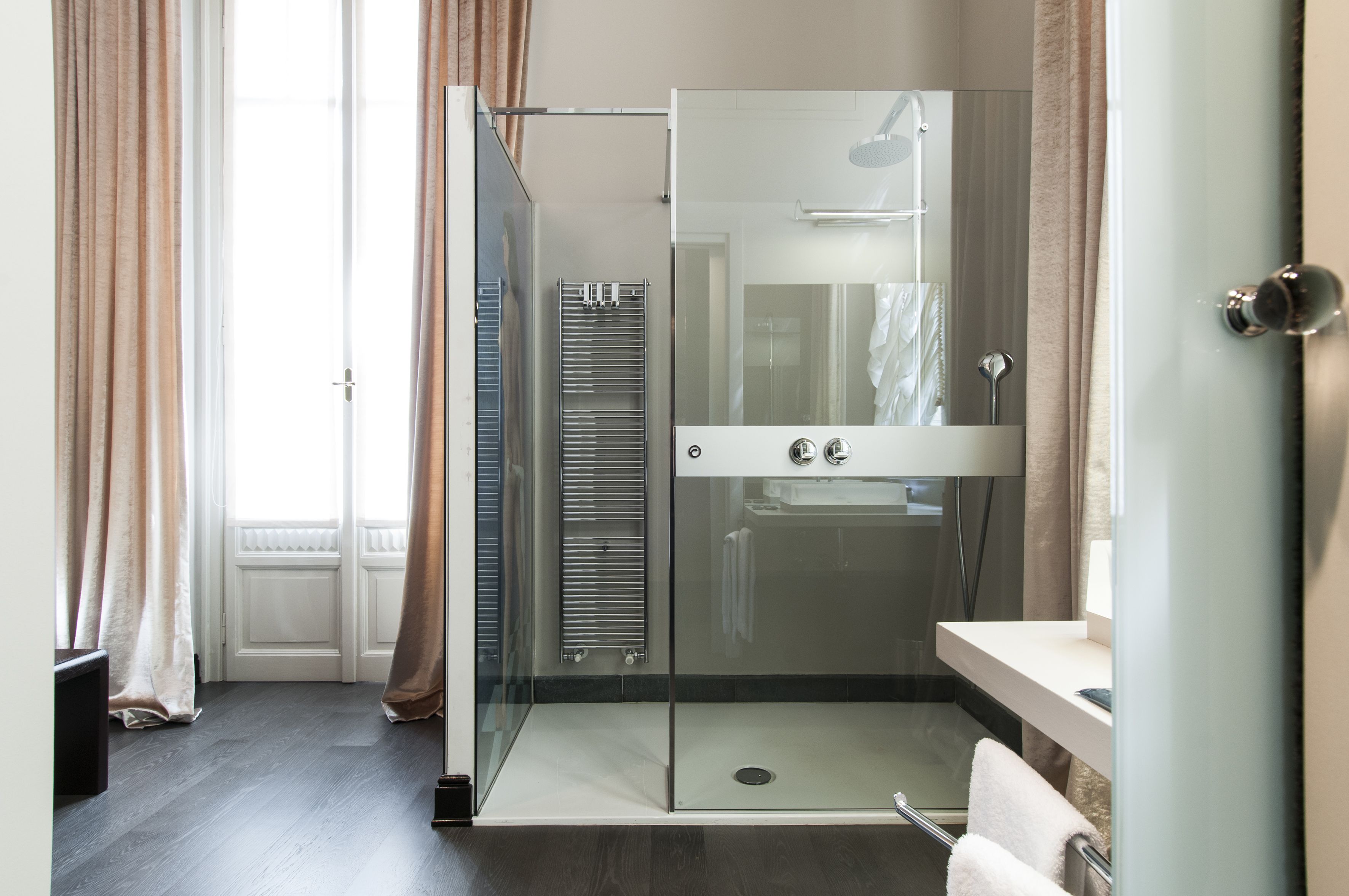 A modern bathroom with a glass shower enclosure, a walk-in shower, and a vanity with a mirror.