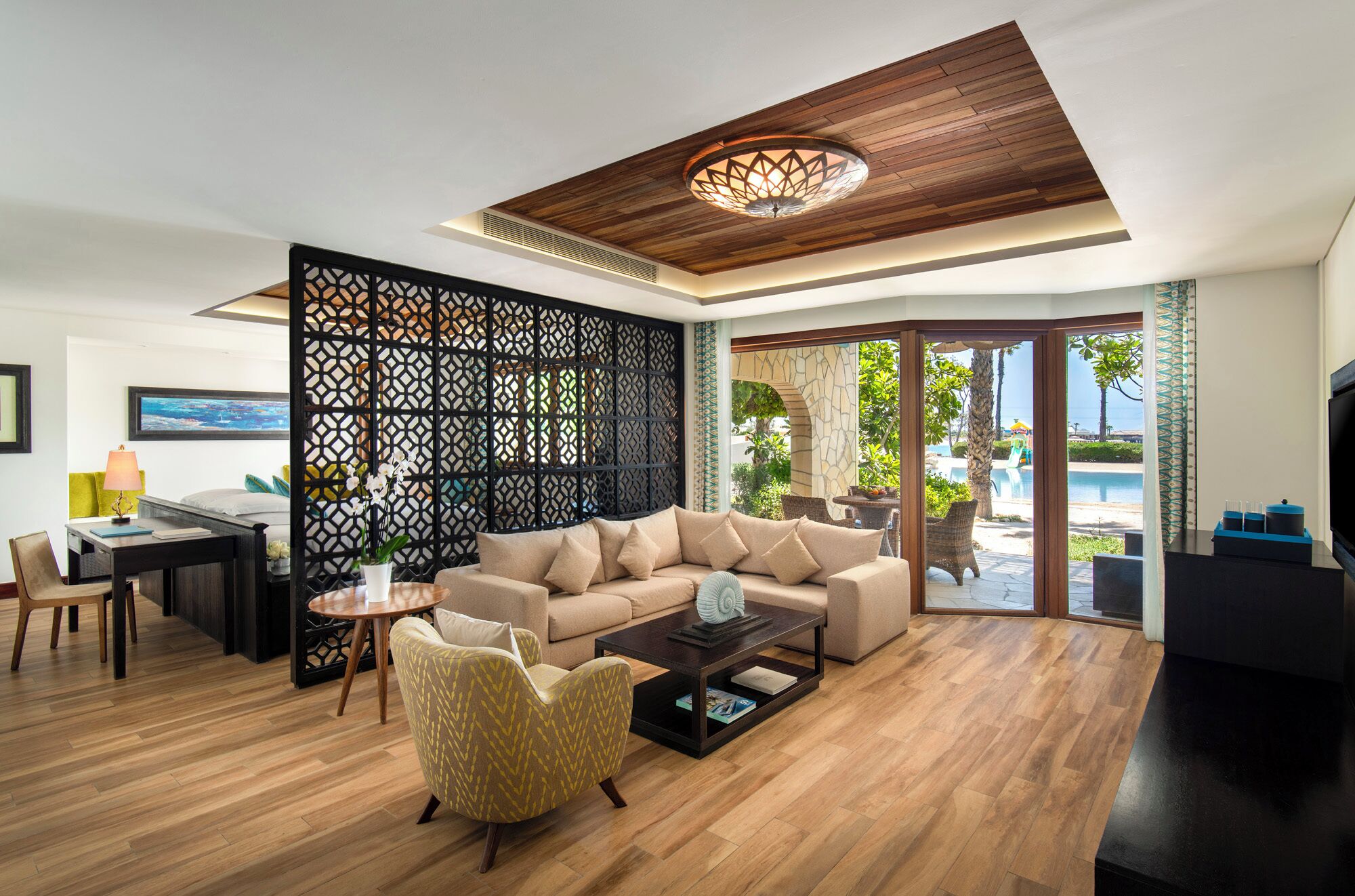 A modern living room with a wooden ceiling, a sofa, a coffee table, and a TV.