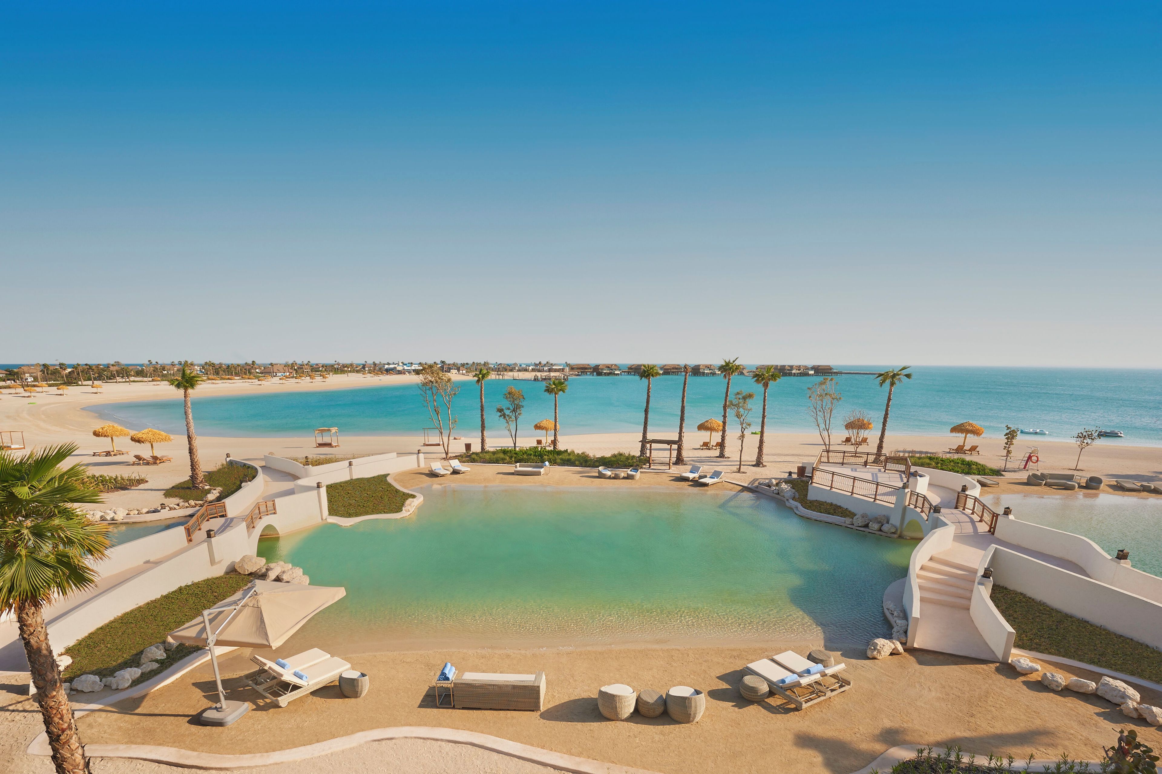 A resort with a pool, beach, and ocean view.