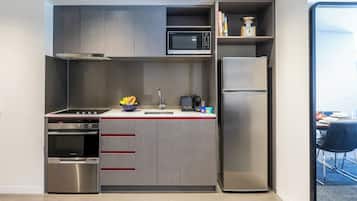 A compact kitchen with a built-in microwave, oven, and refrigerator.