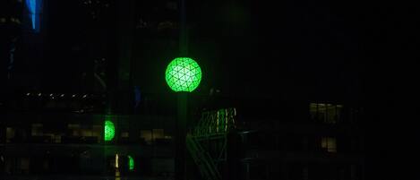 A building with a green spherical light fixture and a blue vertical light structure.