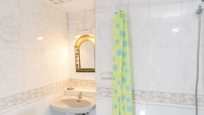 A bathroom with a sink, mirror, and shower. - Arc House Cordoba (Córdoba)