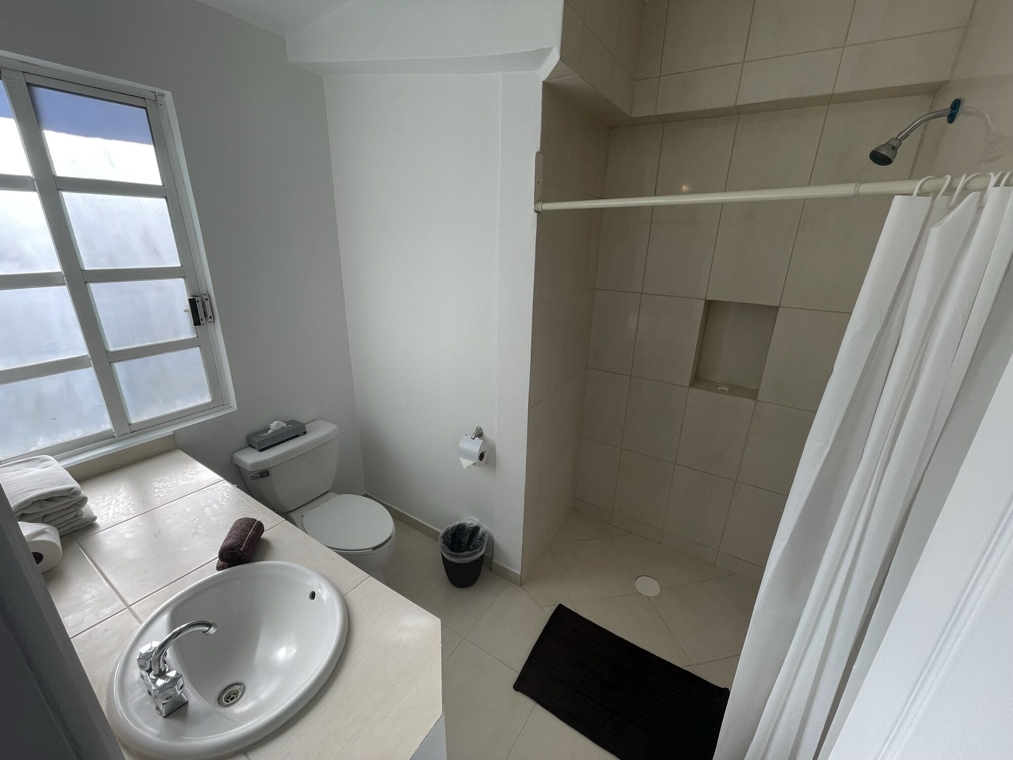 Un baño con lavamanos, inodoro y ducha.
