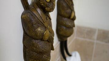 Two wall-mounted rabbit sculptures in a bathroom with a towel hanging below.