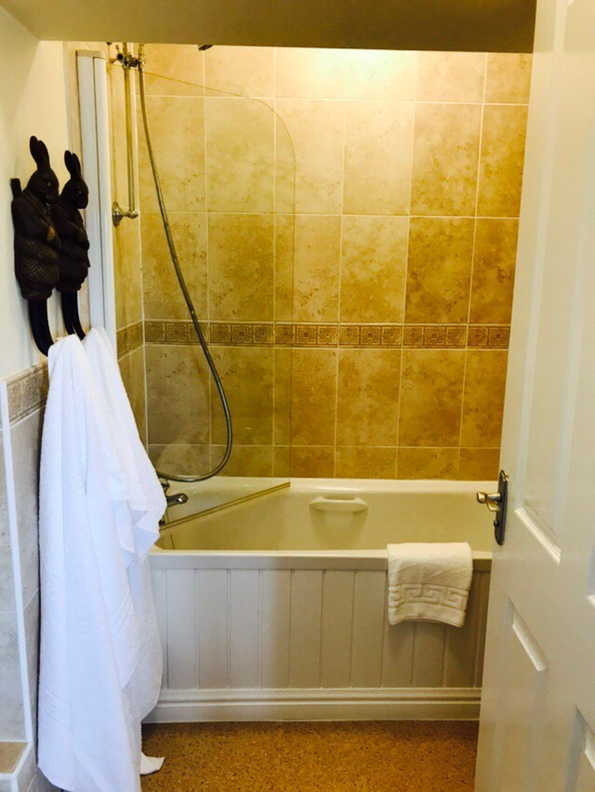 A bathroom with a bathtub, a shower, and a towel rack with towels.