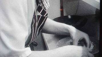 A person wearing a striped tie and a white shirt, working at a counter with a bowl.
