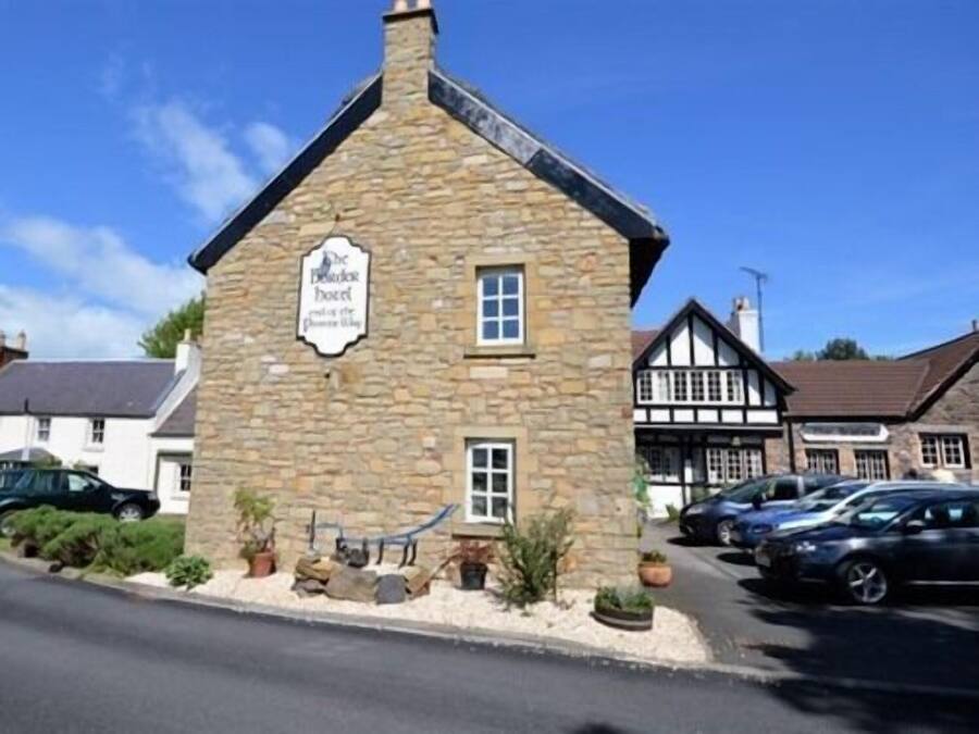 A stone building with a sign that reads "The Blacksmith Pub."