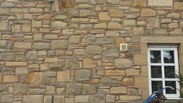A stone building with a sign reading "The Border hotel end of the Pennine Way".