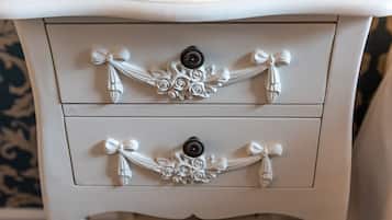 A white dresser with two drawers, each adorned with a decorative bow and a central knob.