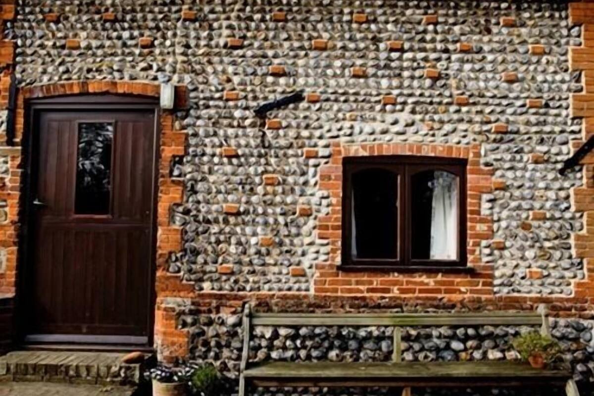A rustic building with a stone wall and a wooden door.
