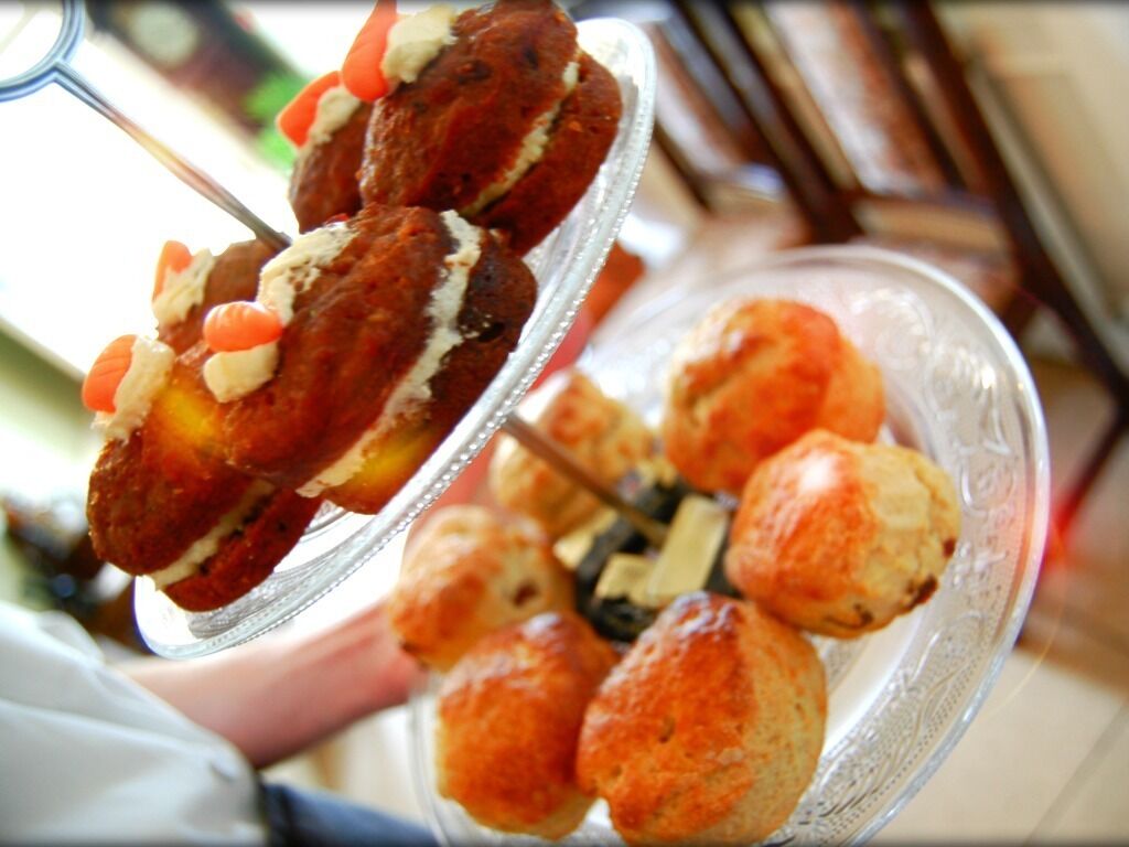 A dessert platter with various pastries, including a skewered item and round buns.