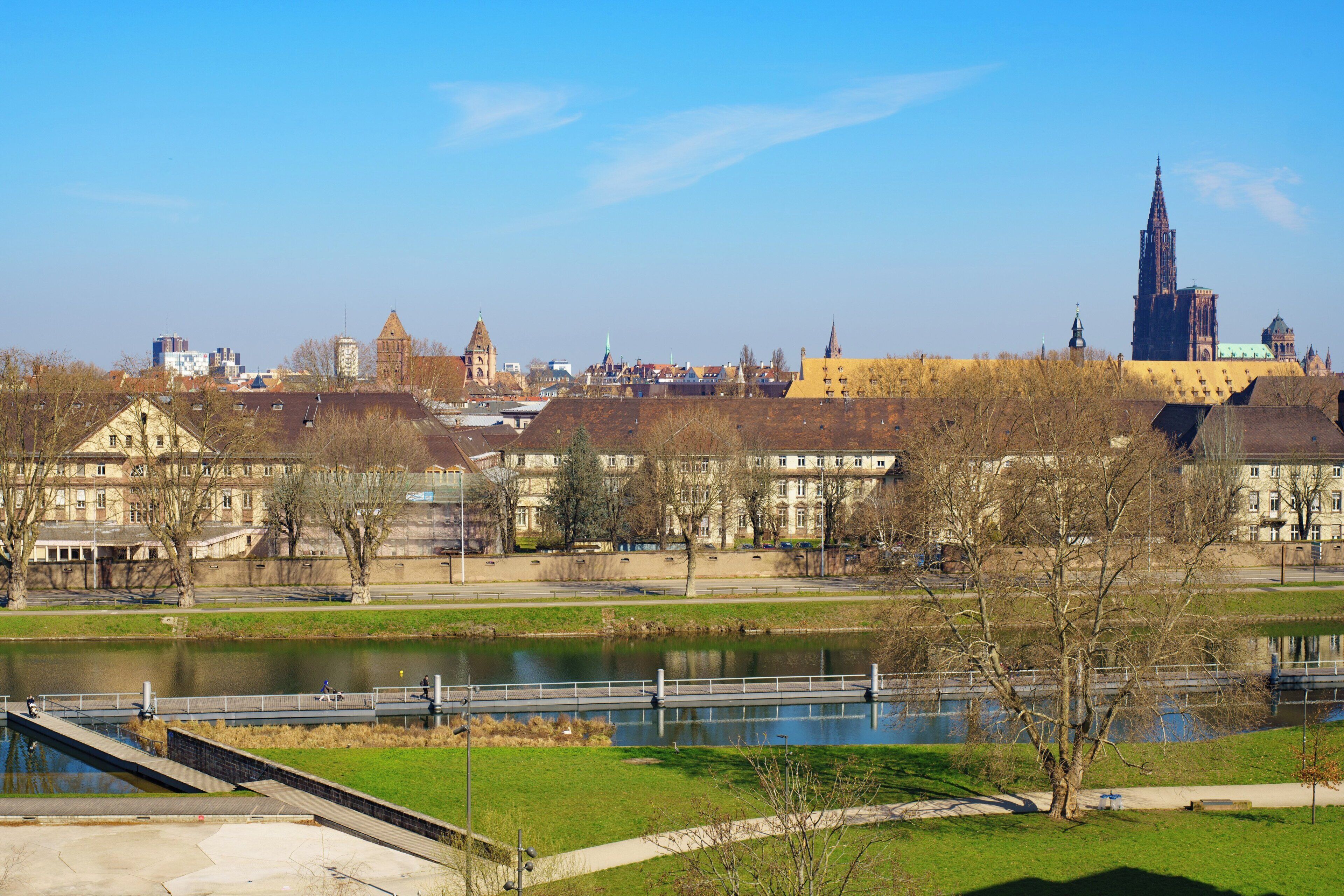 A riverside view with a bridge, buildings, and a prominent tower.