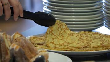 A stack of plates and a person using a spatula to serve food.