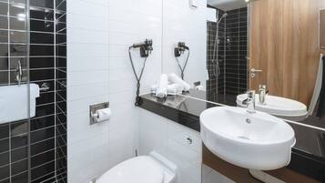 Une salle de bain moderne équipée de toilettes, d’un bidet et de deux lavabos.