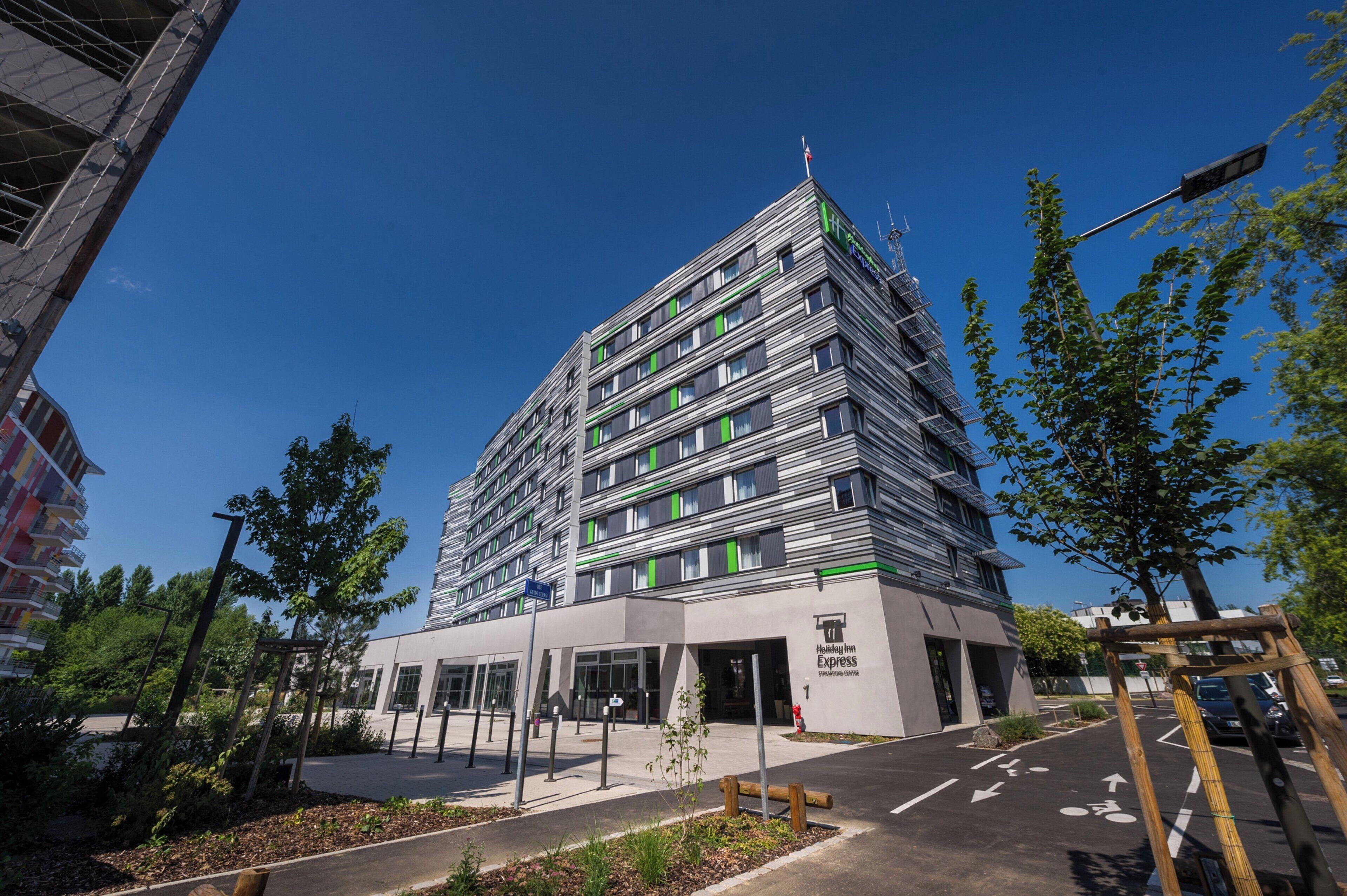 Een hotel met meerdere verdiepingen, met een modern design, een opvallende entree en een heldere lucht erboven.