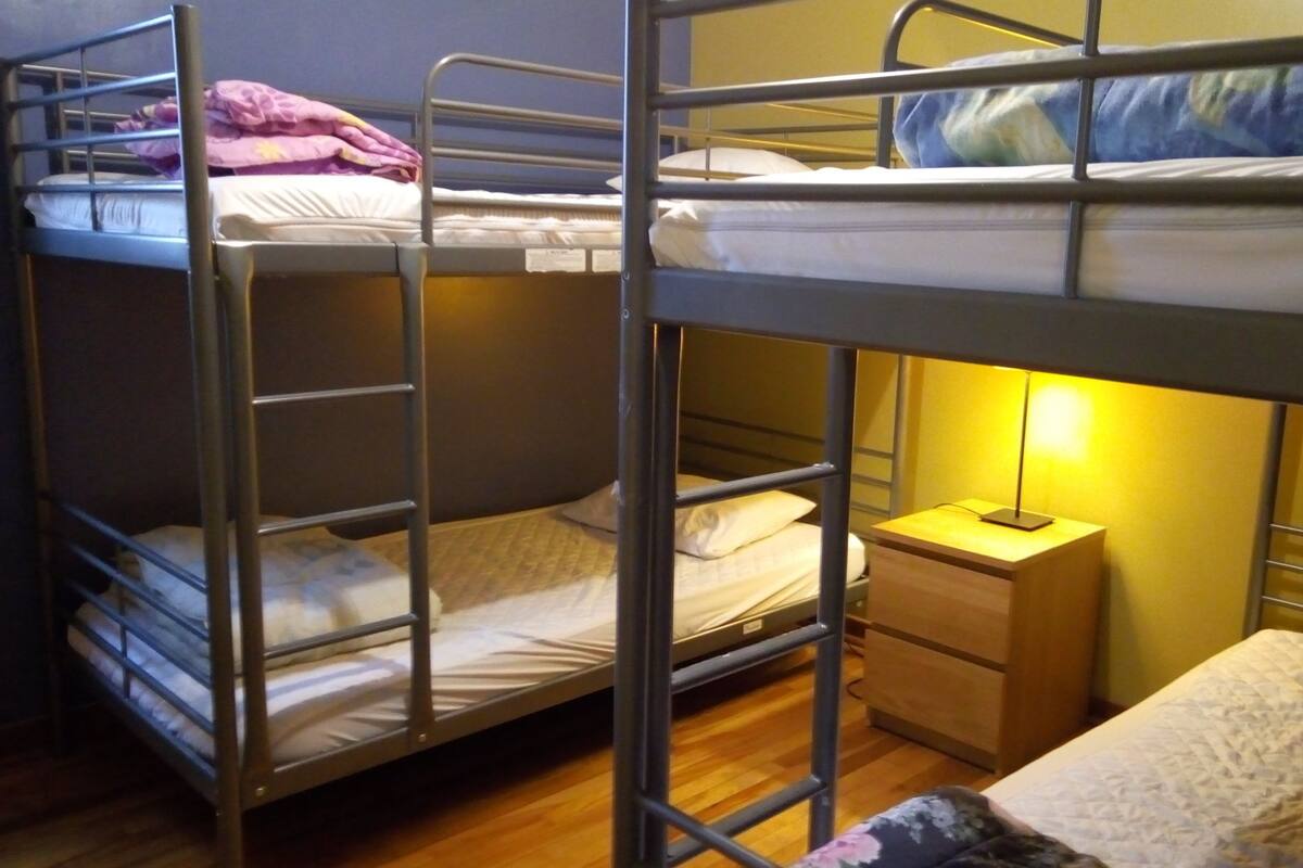A bunk bed room with a nightstand and a lamp.