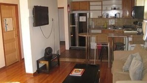 A compact living space with a kitchenette, a dining area, and a seating area with a sofa and a coffee table. - Ottawa Backpackers Inn (Ottawa)