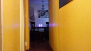A narrow hallway with yellow walls, wooden flooring, and a patterned rug. - Ottawa Backpackers Inn (Ottawa)