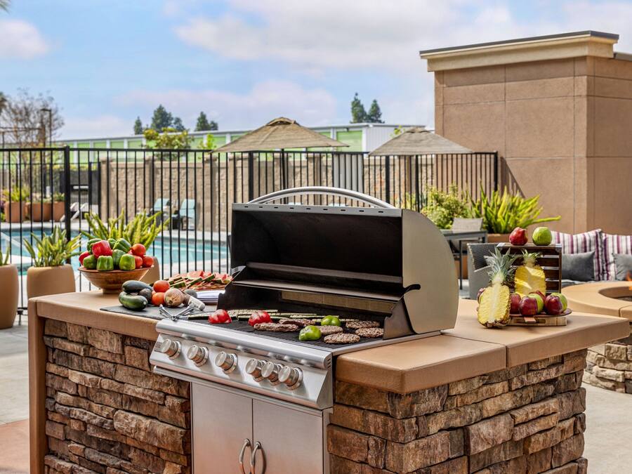 Una cocina exterior con una parrilla, estufa y un pozo para fuego.