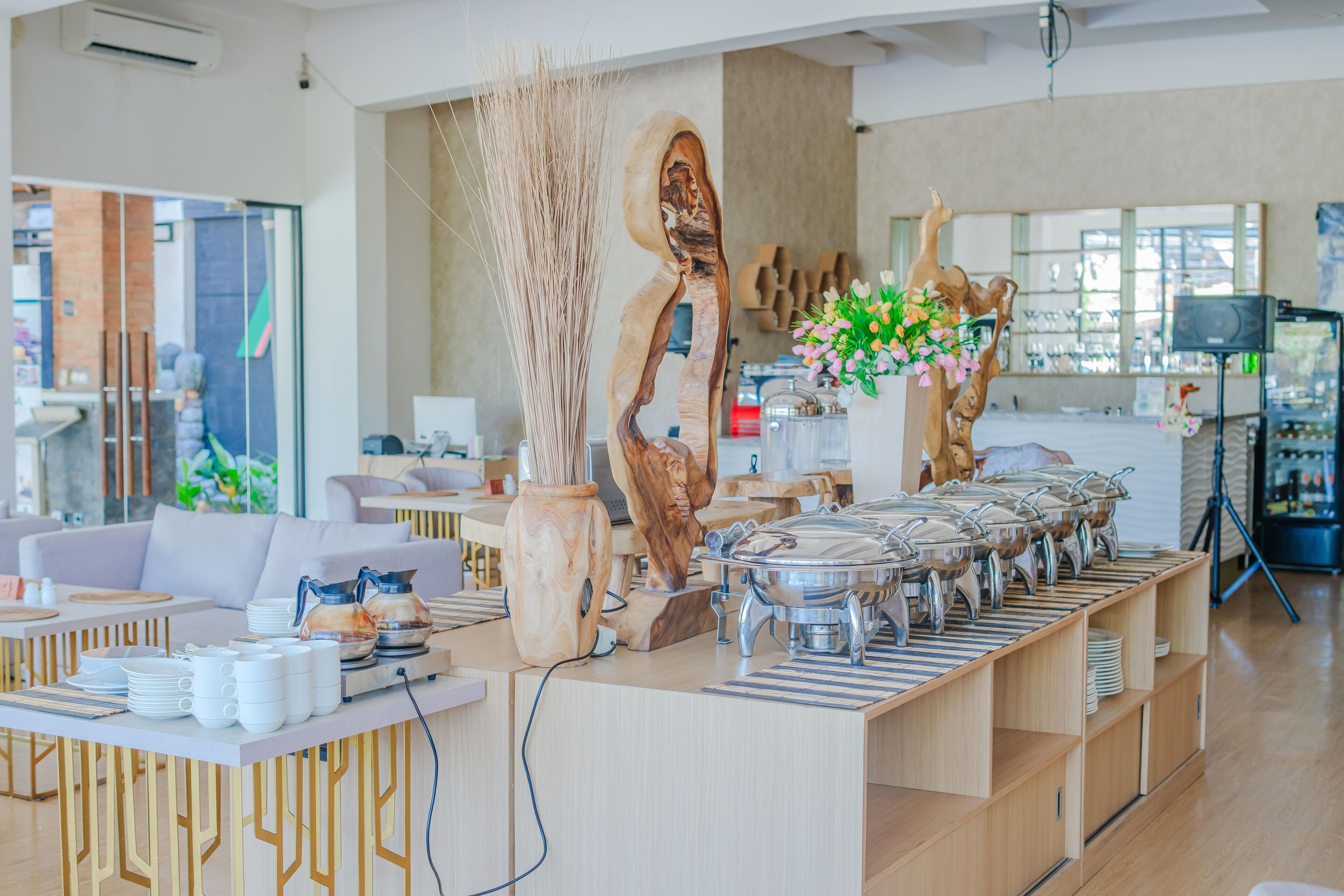 A modern dining area with a buffet setup, including a variety of dishes and a decorative centerpiece.