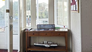 A room with a wooden desk, a ship model, and a chandelier. - Smartsway Hotel & Wellness (Eastbourne)