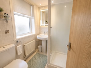 A modern bathroom with a toilet, sink, shower, and a window. - Smartsway Hotel & Wellness (Eastbourne)