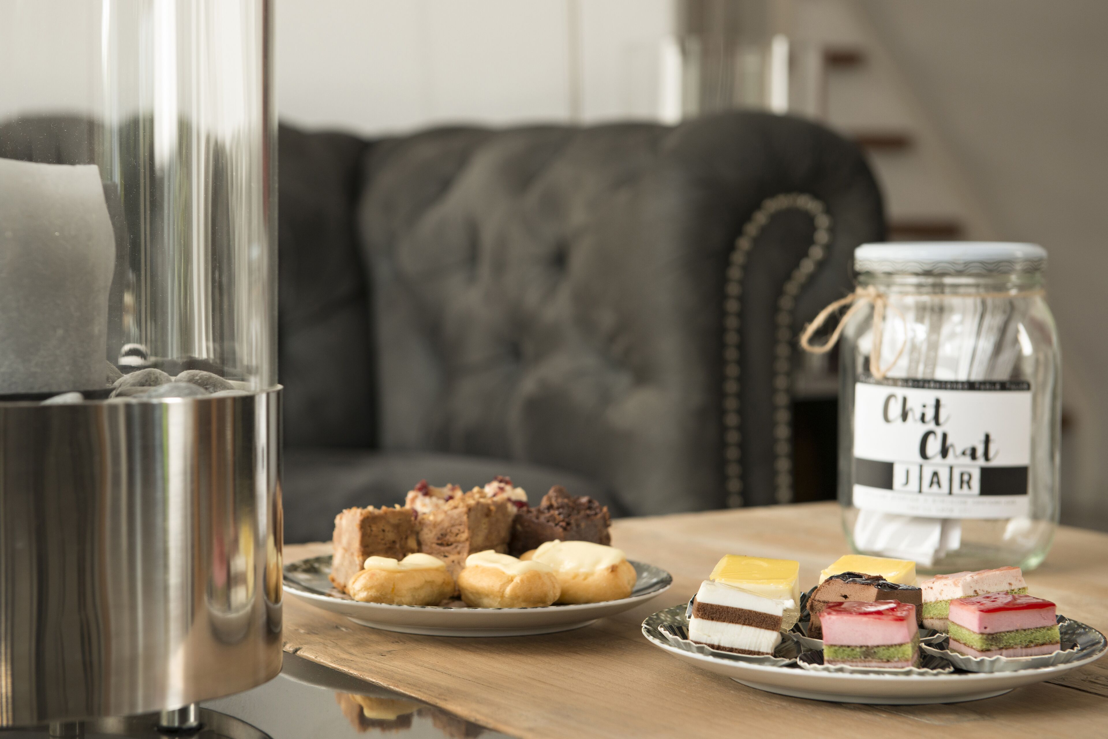 Uma mesa com diversos doces e um pote de vidro com a etiqueta 