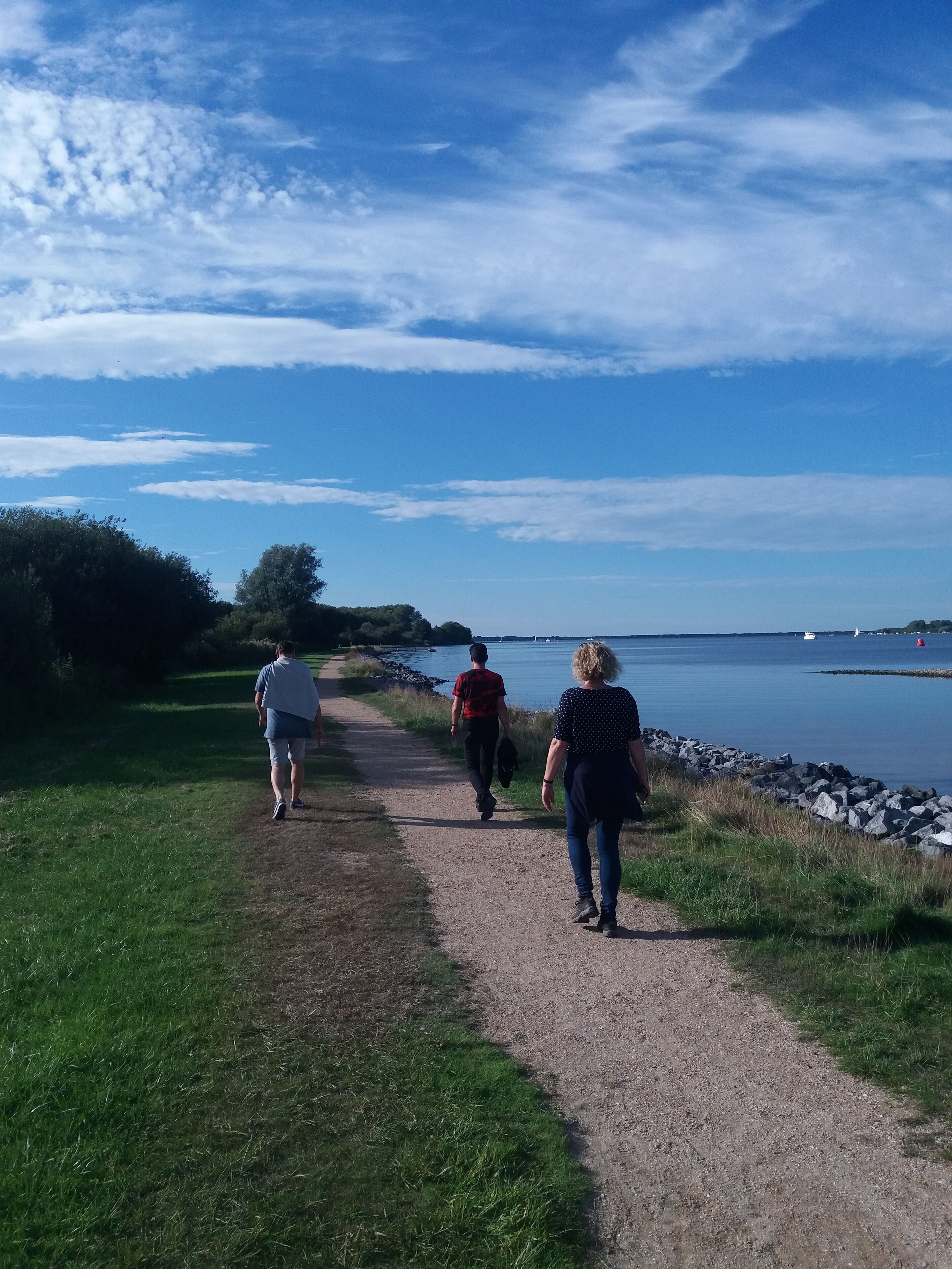 Een pad langs een meer met een heldere lucht.