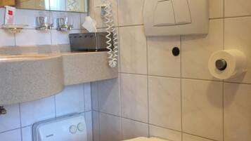 Un bagno moderno con un water, un lavandino, uno specchio e un asciugamani ad aria.