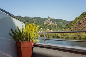 Vista de un castillo en una colina, con un río al frente.