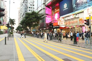 A busy urban street with pedestrians crossing a zebra crossing. - New Grand Guest House (Kowloon)