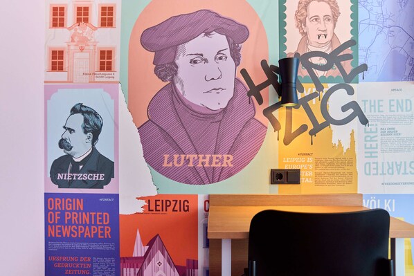 Una pared con varios carteles y un escritorio.