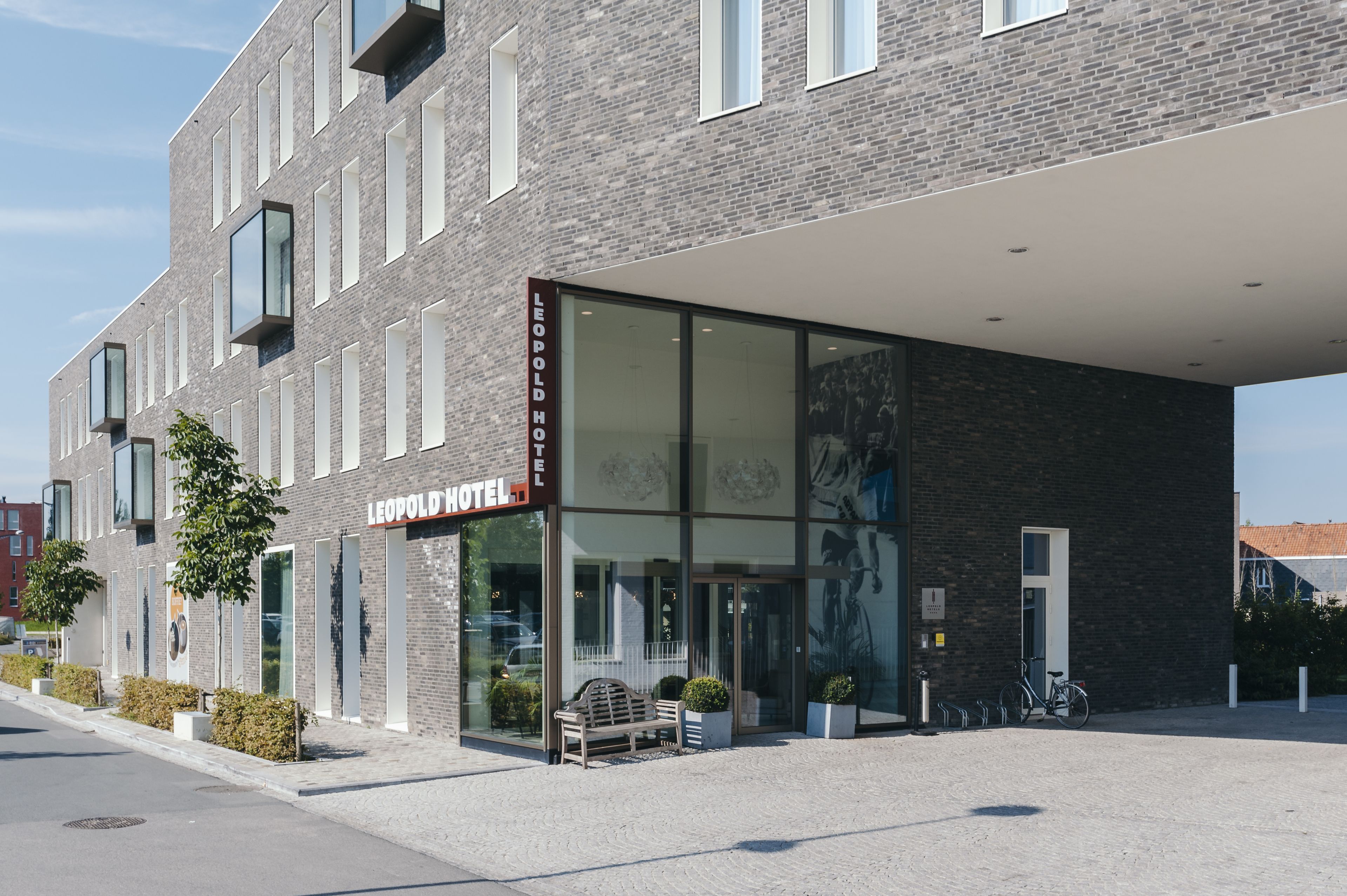 A LEOPOLD HOTEL with a modern facade, large windows, and a covered entrance area.