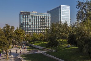 A modern hotel with a glass facade, surrounded by a park with a skate park and walking paths. - Radisson Blu Plaza El Bosque Santiago (Santiago)