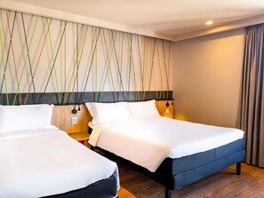 A hotel room with two beds, a wooden floor, and a wall with a geometric pattern. - Ibis Styles Porto Alegre Moinhos de Vento (Porto Alegre)
